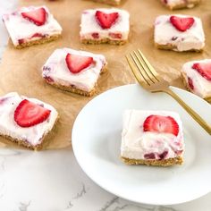 strawberries and cream squares are on a plate with a gold fork next to them