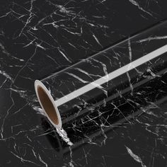 a roll of black and white marble paper on top of a table with the end rolled up