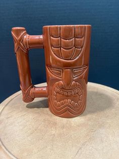 a brown ceramic mug with an angry face on it