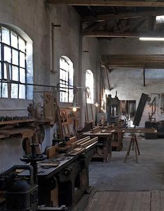 an old factory with lots of woodworking tools on the tables and in front of large windows