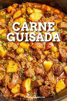 a pot filled with meat and potatoes on top of a wooden table next to a sign that reads carne gusada