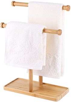 two white towels are hanging on the wooden holder with bamboo handles and bars for storage