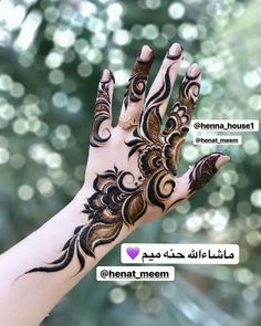 a woman's hand with henna on it and some words written in arabic