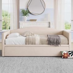 a white daybed sitting in front of two windows