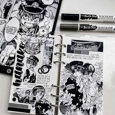 an open notebook with some drawings on it and two pens next to the book cover