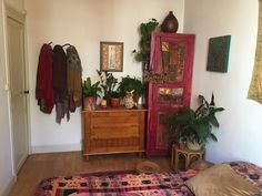 a bed room with a dresser and some plants