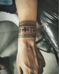 a person with a wrist tattoo on their left arm and the other hand holding an object