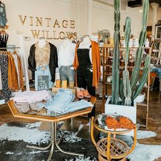 an old fashion store with cactus and clothing on display