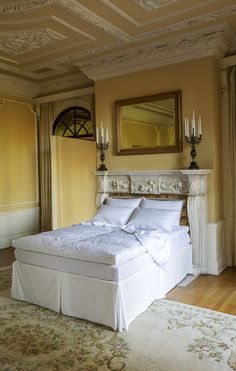 a bed with white sheets and pillows in a room