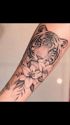 a tiger and flowers tattoo on the arm