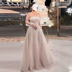 a woman standing in front of a wedding cake wearing a dress with sequins