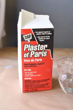 a carton of plaster sitting on top of a table next to a measuring cup