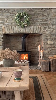 a living room filled with furniture and a fire place next to a stone fireplace covered in wreaths