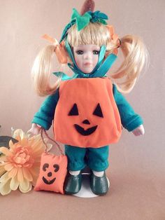 a doll with blonde hair wearing a pumpkin costume