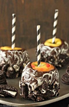 chocolate covered desserts on a plate with two lit candles sticking out of the top