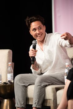 a man sitting in a chair holding a microphone