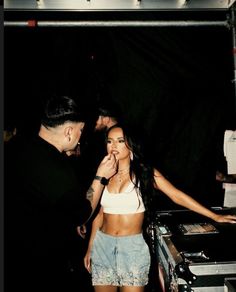 a woman standing next to a dj at a party