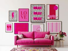 a pink couch sitting in front of a wall with pictures on it's side