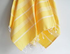 a yellow and white towel hanging on the wall