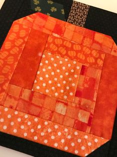 an orange and black patchwork piece with white dots