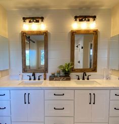 a bathroom with double sinks and two mirrors