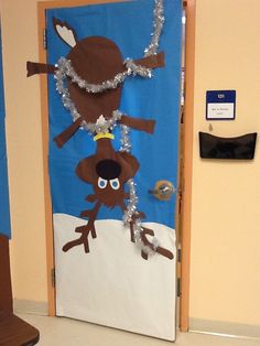 a door decorated with an image of two monkeys on the snow covered ground and silver garlands around their necks