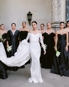 a group of women in black and white dresses standing next to each other