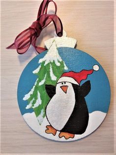 an ornament with a penguin wearing a santa hat