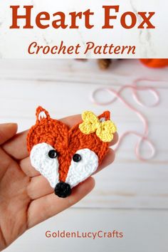 a hand holding a crochet fox applique in it's palm