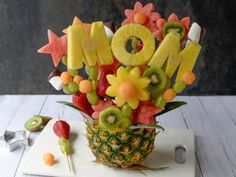 a pineapple decorated with fruit and the word mom spelled out