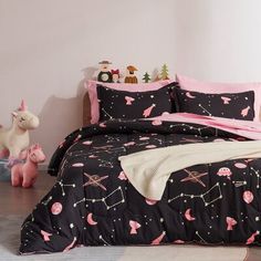 a bed with pink and black comforters in a room next to a toy horse