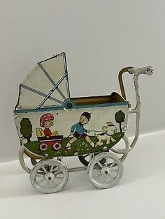 an old fashioned baby's stroller with a boy and girl in it on wheels