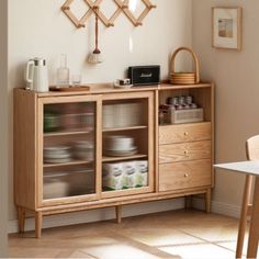 a wooden cabinet with glass doors and shelves on the top, in front of a dining room table