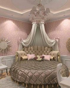 a bed room with a neatly made bed next to two chairs and a mirror on the wall