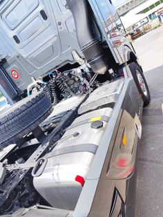 the back end of a silver truck parked in a parking lot next to other vehicles