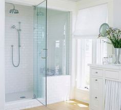 a bathroom with a stand up shower next to a sink