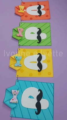 four different colored paper cut outs with numbers and shapes on them, one is for the letter e