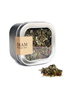 a tin filled with green tea next to a pile of dried leaves