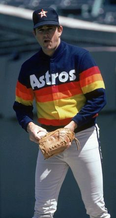 a baseball player wearing a rainbow shirt and holding a catchers mitt in his hand