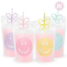 four plastic cups with smiley faces and bows on them, each filled with colored liquid