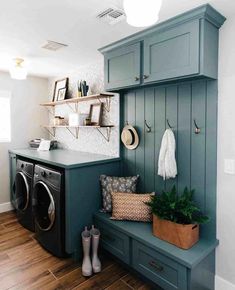 a washer and dryer in a laundry room with green cabinets, wood flooring and wooden floors