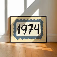 a framed sign sitting on top of a wooden floor in front of a window with the number 1971