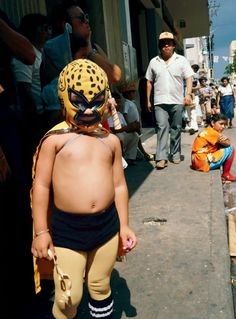 a small child wearing a yellow and black mask on top of it's head