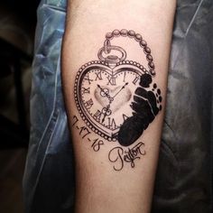 a tattoo on the arm of a person with a heart shaped clock and hand print