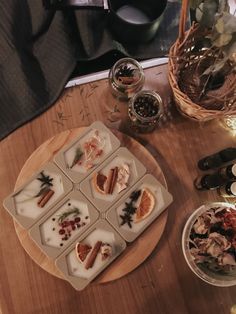 an assortment of appetizers are arranged on a table with candles and other items