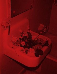 a sink in a bathroom with red light coming from the faucet above it