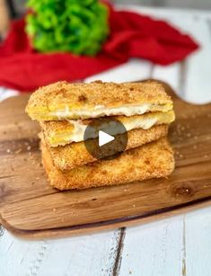 two grilled sandwiches sitting on top of a wooden cutting board