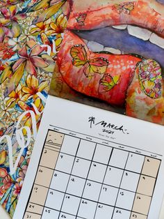 a calendar with images of women's lips and flowers on it next to a painting