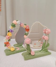 a table topped with pink and yellow flowers next to a mirror