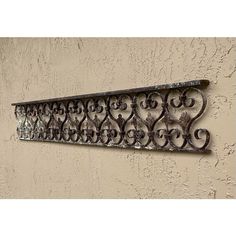 a decorative iron shelf on the side of a building